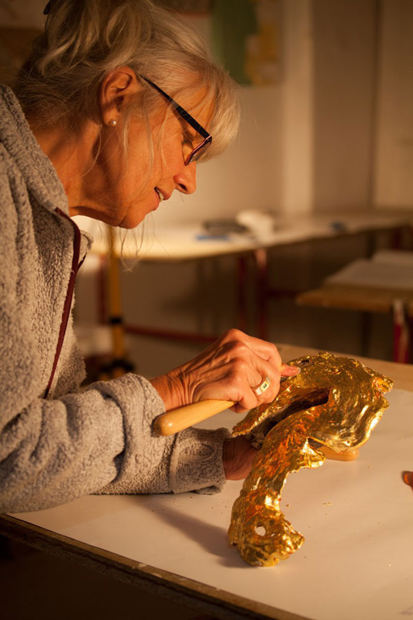 Arbeit an einer Skulptur in Gold von Paula Moreike